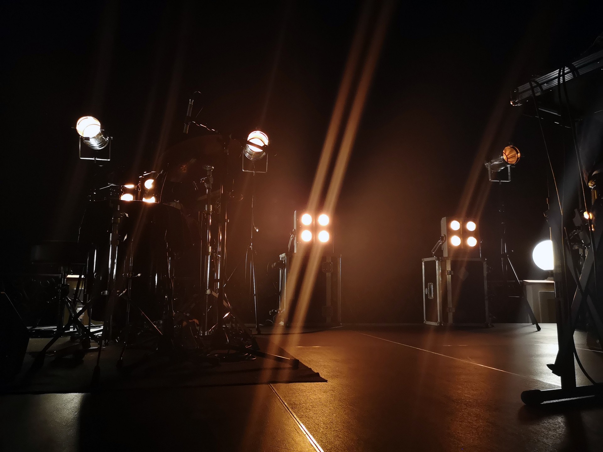 Concert stage and lighting fixtures on it, musical equipment. Smoke from a smoke installation gently breaks yellow light and creates the effect of a gentle glow.